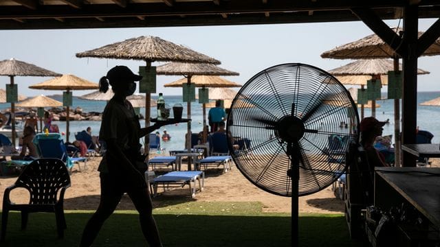 Eine Kellnerin serviert Erfrischungen in einer Strandbar im Dorf Lagonissi. Eine Kellnerin serviert Erfrischungen in einer Strandbar im Dorf Lagonissi.