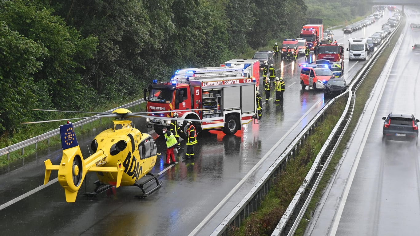 Einsatzkräfte der Feuerwehr und ein Hubschrauber des ADAC stehen auf der A31, wo sich zwei Unfälle ereignet haben.