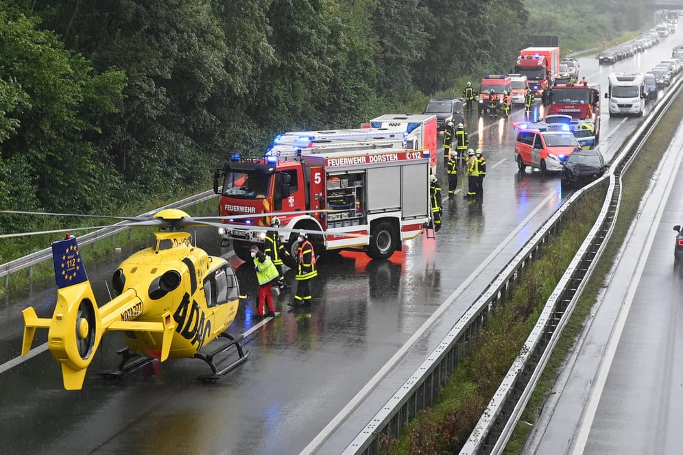 Einsatzkräfte der Feuerwehr und ein Hubschrauber des ADAC stehen auf der A31, wo sich zwei Unfälle ereignet haben.