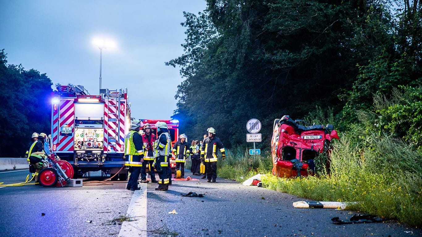 Rettungskräfte stehen neben dem Unfallauto auf der A52: Der Fahrer musste aus seinem Auto befreit werden.