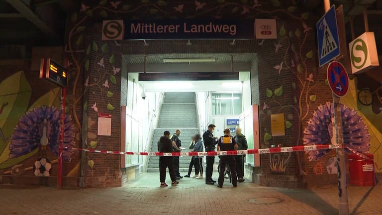 Polizisten befragen im Eingangsbereich zum S-Bahnhof Mittlerer Landweg mögliche Zeugen: Zwei Männer im Alter von 24 Jahren sind bei einer Auseinandersetzung mit einem Messer verletzt worden.