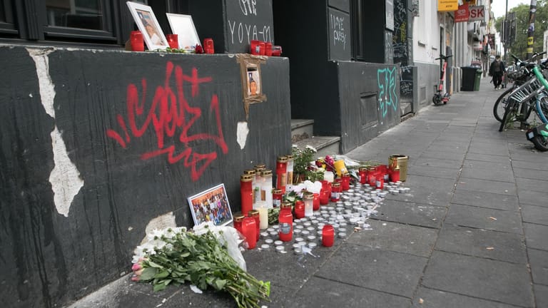 Der Tatort an der Zülpicher Straße ist nun ein Trauerort: Bekannte und Freunde haben hier neben Blumen und Kerzen auch Fotos des getöteten 18-Jährigen niedergelegt