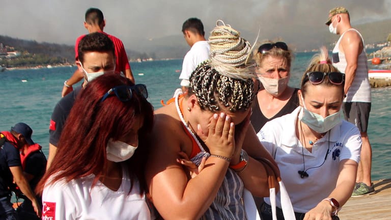 Sanitäterinnen helfen einer evakuierten Frau in Bodrum (Archivbild vom Donnerstag): In der türkischen Stadt mussten erneut Hunderte Menschen mit Booten vor Waldbränden gerettet werden.