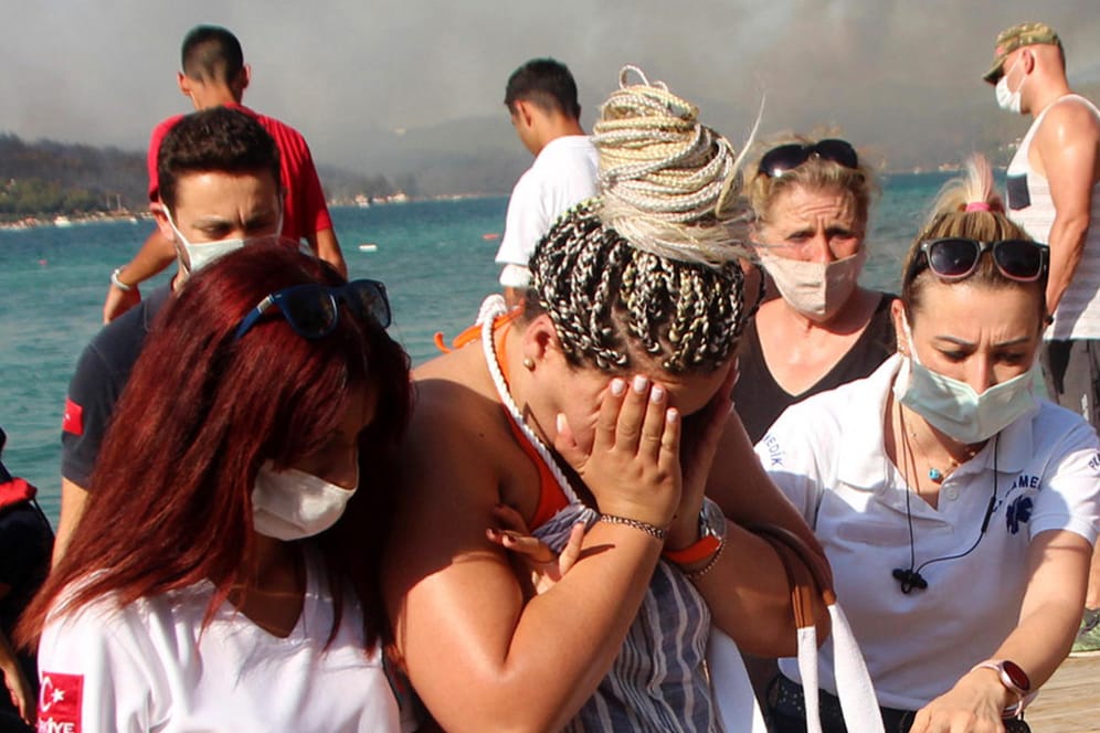 Sanitäterinnen helfen einer evakuierten Frau in Bodrum (Archivbild vom Donnerstag): In der türkischen Stadt mussten erneut Hunderte Menschen mit Booten vor Waldbränden gerettet werden.