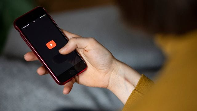 Das Logo der App YouTube auf einem Smartphone: Das Videoportal hat den Nachrichtensender Sky News Australia für eine Woche auf seiner Plattform gesperrt.