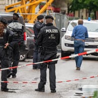 Polizisten stehen nach einer Schießerei in der gesperrten Milchstrasse im Stadtteil Haidhausen: Ein Familienstreit soll der Auslöser gewesen sein.