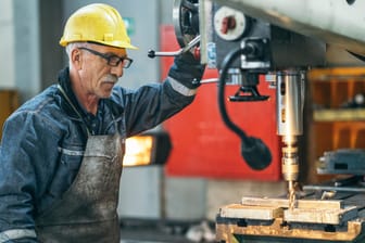 Ein älterer Drechsler an einer Werkbank (Symbolbild): Die Arbeitgeber möchten eine Debatte über längeres Arbeiten.