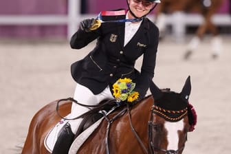 Mit der Goldmedaille um den Hals reitet Julia Krajewski nach der Siegerehrung auf Amande de B`Neville eine Ehrenrunde.