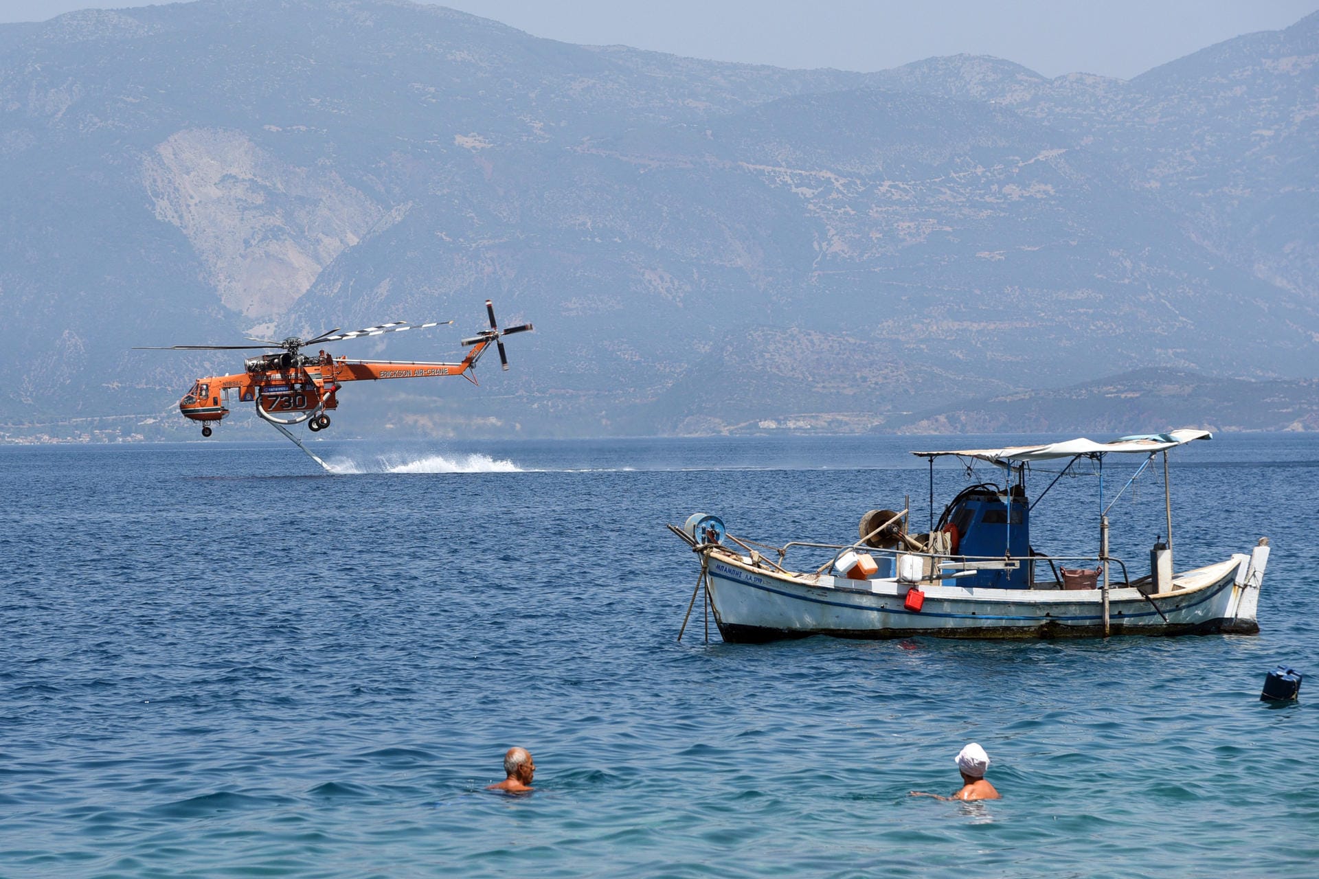 Ein Hubschrauber tankt in der Nähe des griechischen Dorfes Ziria Wasser aus dem Meer, um es über einem Waldbrand östlich der Stadt Patras abzulassen. Laut Zivilschutz waren seit Samstag 58 Brände auf der Halbinsel ausgebrochen, von denen die meisten jedoch rasch unter Kontrolle gebracht werden konnten.