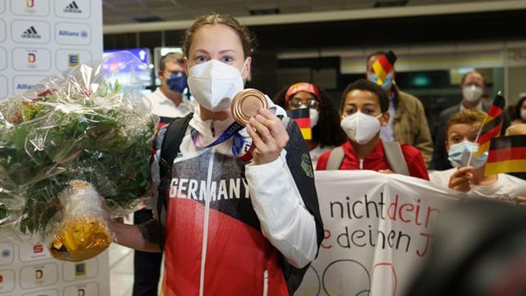 Sarah Köhler steht mit ihrer Bronzemedaille nach ihrer Ankunft aus Tokio auf dem Frankfurter Flughafen.