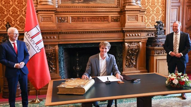 Ehre in Hamburg: Tennis-Olympiasieger Alexander Zverev (M) trägt sich in das Goldene Buch der Stadt ein. Ehre in Hamburg: Tennis-Olympiasieger Alexander Zverev (M) trägt sich in das Goldene Buch der Stadt ein.