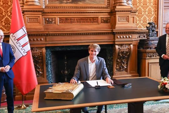 Ehre in Hamburg: Tennis-Olympiasieger Alexander Zverev (M) trägt sich in das Goldene Buch der Stadt ein.
