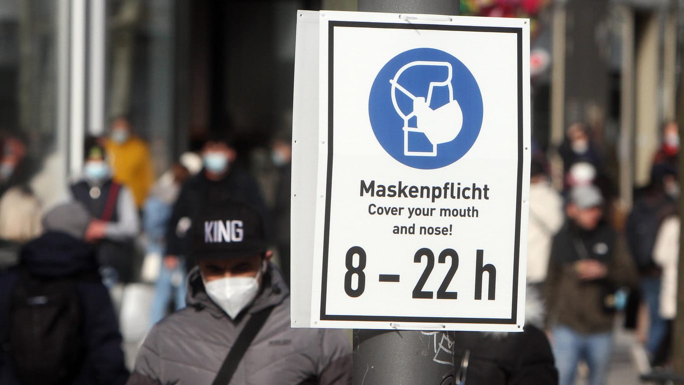Schild mit Piktogramm und Aufschrift Maskenpflicht von 8 bis 22 Uhr hängt in Frankfurt (Archivbild). Die Zahl der Corona-Infektionen steigt weiter.