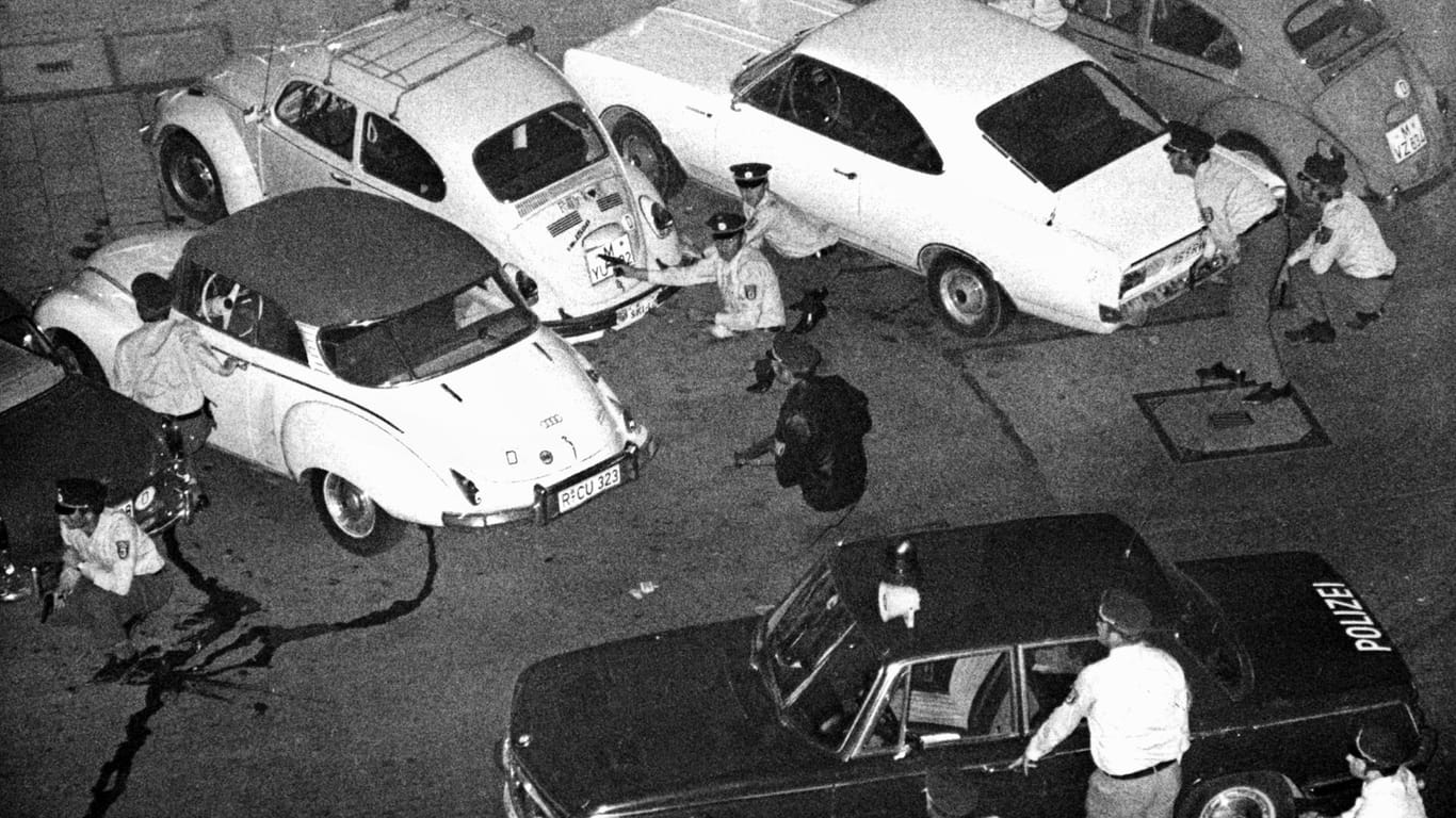 Bewaffnete Polizisten hinter den Autos (Archivbild): Die Beamten sind gegenüber der Deutschen Bank in Deckung gegangen.