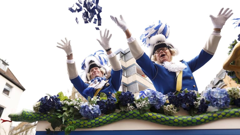 Blaue Funken werfen Kamellen am Kölner Rosenmontagszug: Jährlich werden hier 300 Tonnen Süßigkeiten geworfen.