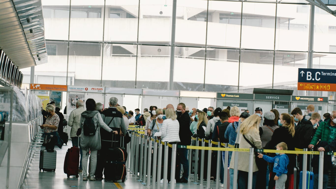 Reisende warten im Kölner Flughafen (Archivbild): In den Sommerferien kam es im Terminal 1 des Airports teils zu chaotischen Szenen.