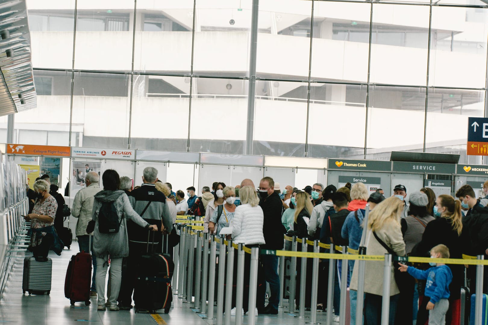 Reisende warten im Kölner Flughafen (Archivbild): In den Sommerferien kam es im Terminal 1 des Airports teils zu chaotischen Szenen.