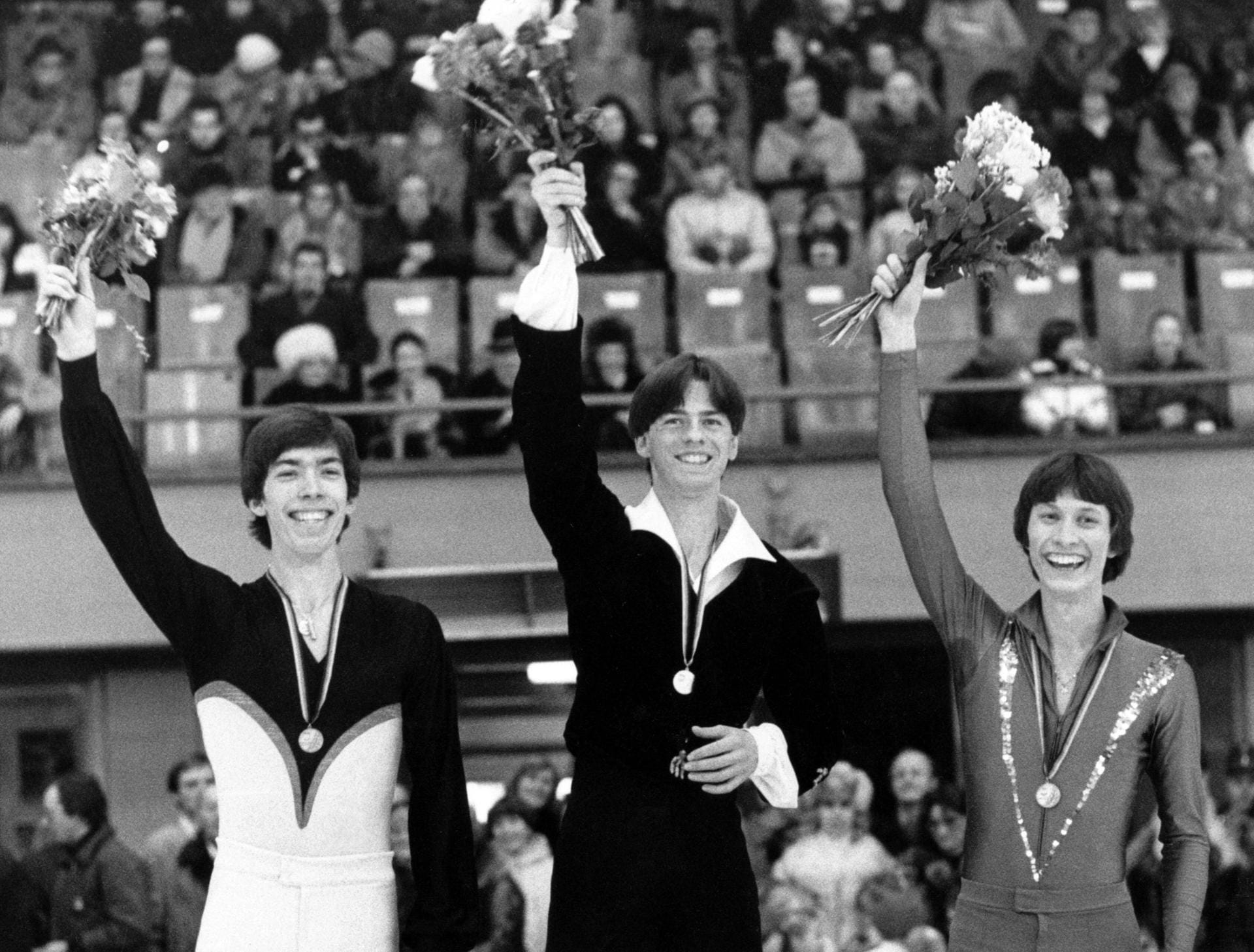 1980: Rudi Cerne (Mitte) freut sich bei der Siegehrung der Deutschen Meisterschaft im Eiskunstlaufen.
