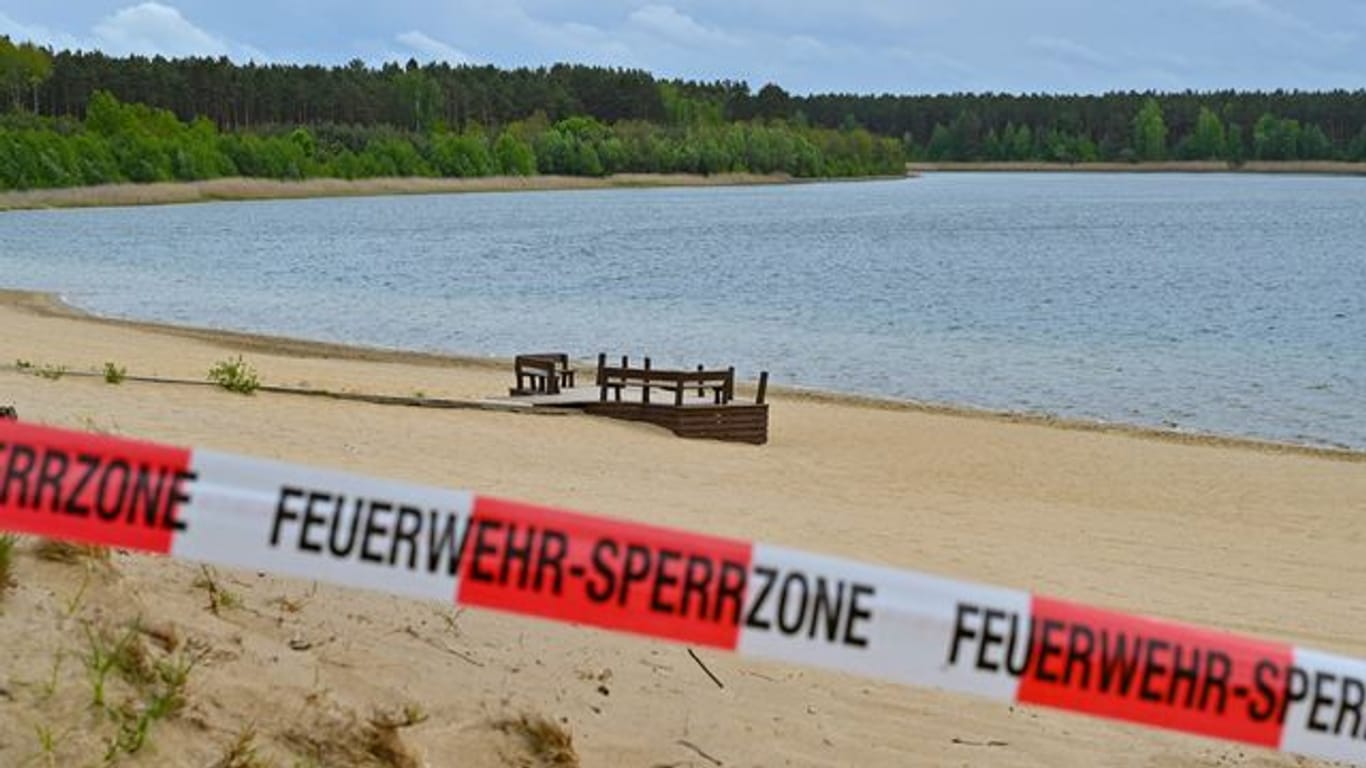 Mit einem Flatterband ist ein Zugang zum Strand des Helenesees abgesperrt (Archivbild): Die Stadt zeigte sich "sehr erschrocken" über den Zwischenbericht.