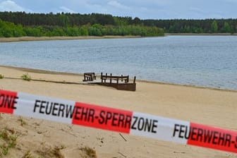 Mit einem Flatterband ist ein Zugang zum Strand des Helenesees abgesperrt (Archivbild): Die Stadt zeigte sich "sehr erschrocken" über den Zwischenbericht.