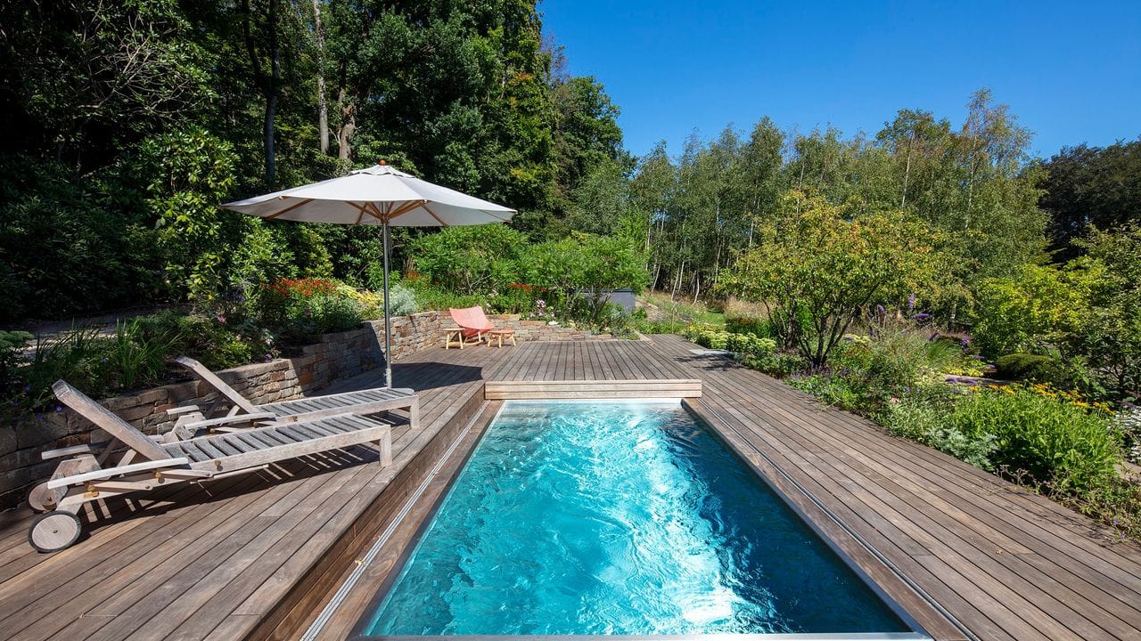 Multifunktionale Abdeckung: Dank eines verschließbaren Holzdecks kann aus einem Pool an kühlen Tagen auch eine Terrasse werden.