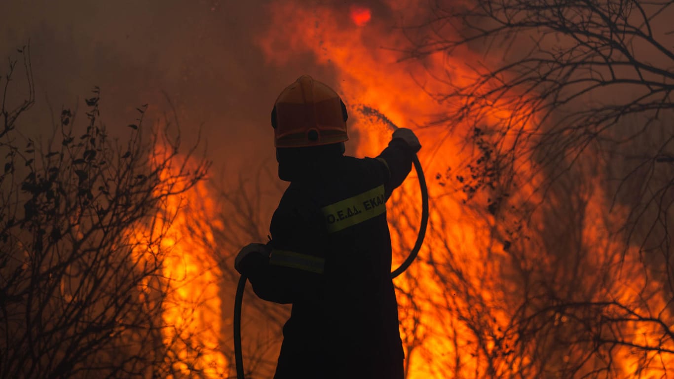 Ein Feuerwehrmann im Einsatz gegen den Waldbrand in einem Vorort von Athen.
