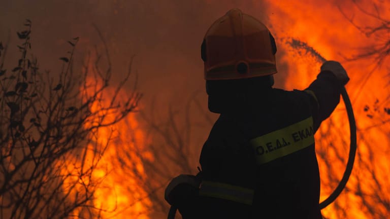 Ein Feuerwehrmann im Einsatz gegen den Waldbrand in einem Vorort von Athen.