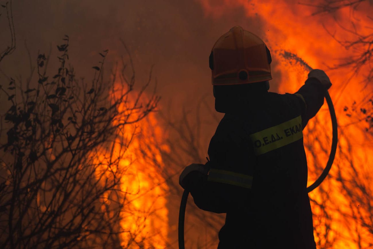 Ein Feuerwehrmann im Einsatz gegen den Waldbrand in einem Vorort von Athen.