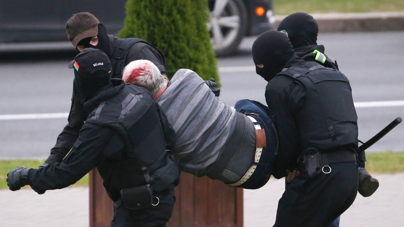Polizisten tragen einen blutüberströmten Mann fort (Archivfoto): Die Proteste wurden brutal niedergeschlagen.