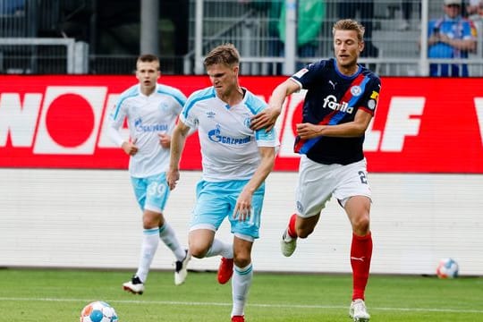 Schalkes Marius Bülter (M) setzt sich im Zweikampf gegen Kiels Hauke Wahl (r) durch (Archivbild): Die Kieler sind aktuell Tabellenletzte.