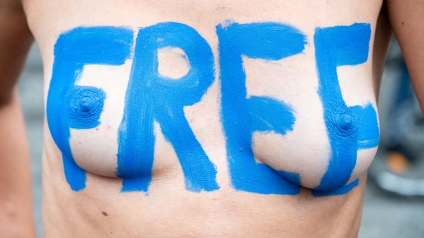 "Free" steht auf der Brust einer Demo-Teilnehmerin