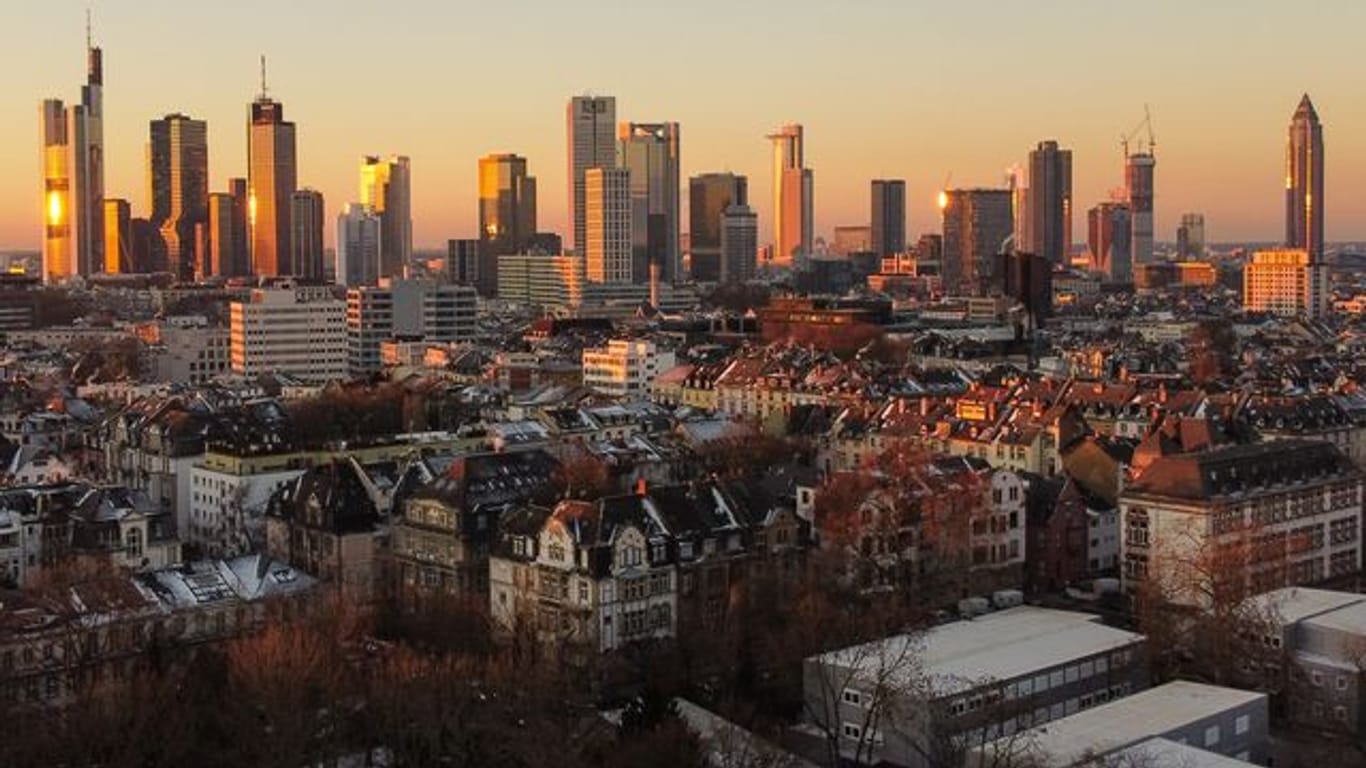 Das Licht der aufgehenden Sonne streift die Hochhäuser Frankfurts