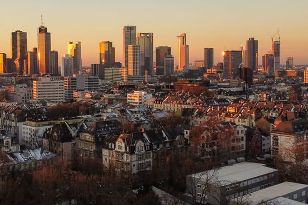 Das Licht der aufgehenden Sonne streift die Hochhäuser Frankfurts
