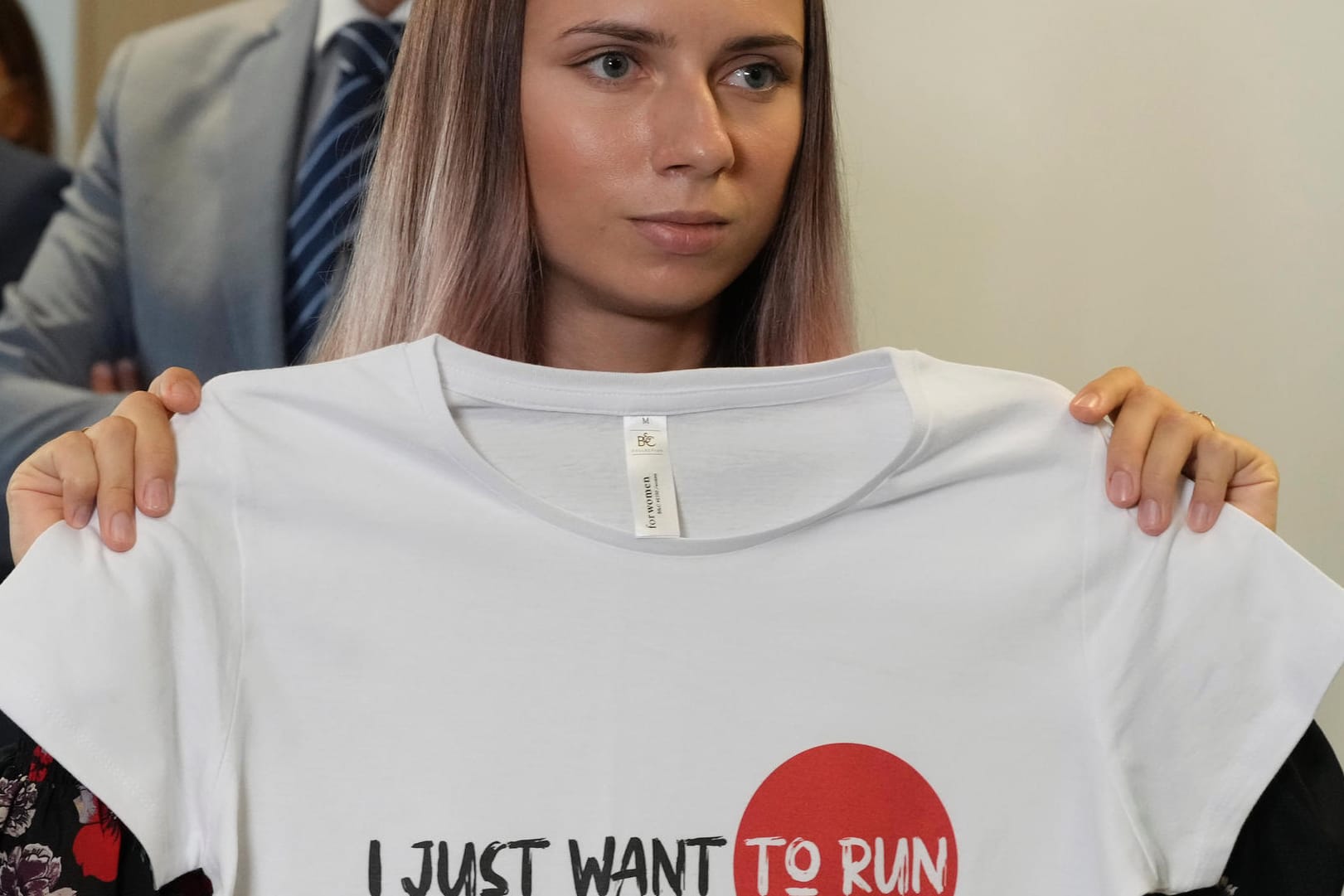 Kristina Timanowskaja: Die 24-Jährige hält ein T-Shirt hoch mit der Aufschrift "Ich will doch nur laufen".