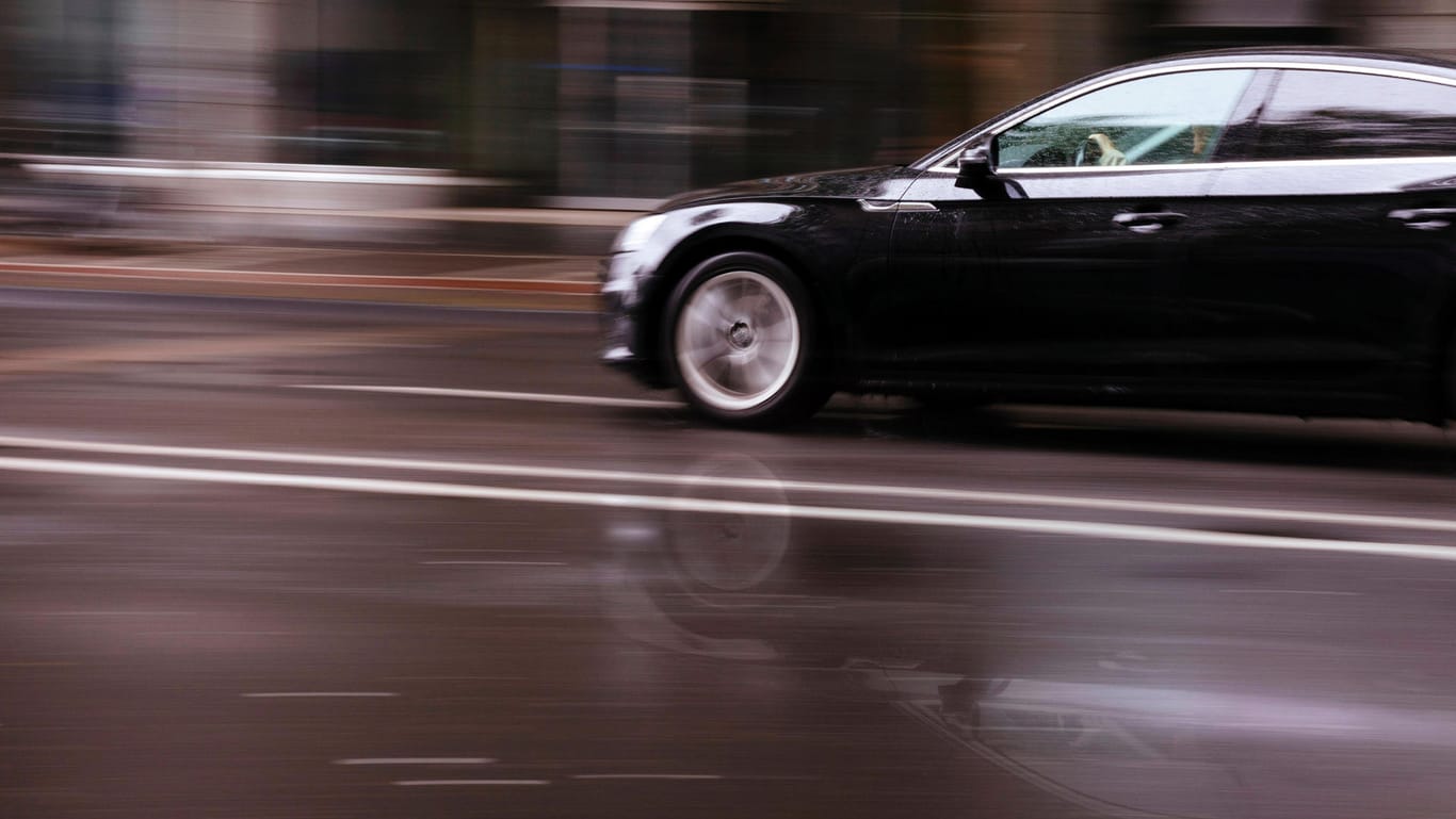 Ein Auto fährt über eine regennasse Fahrbahn (Symbolbild): In München haben zwei Männer ein illegales Rennen gefahren.