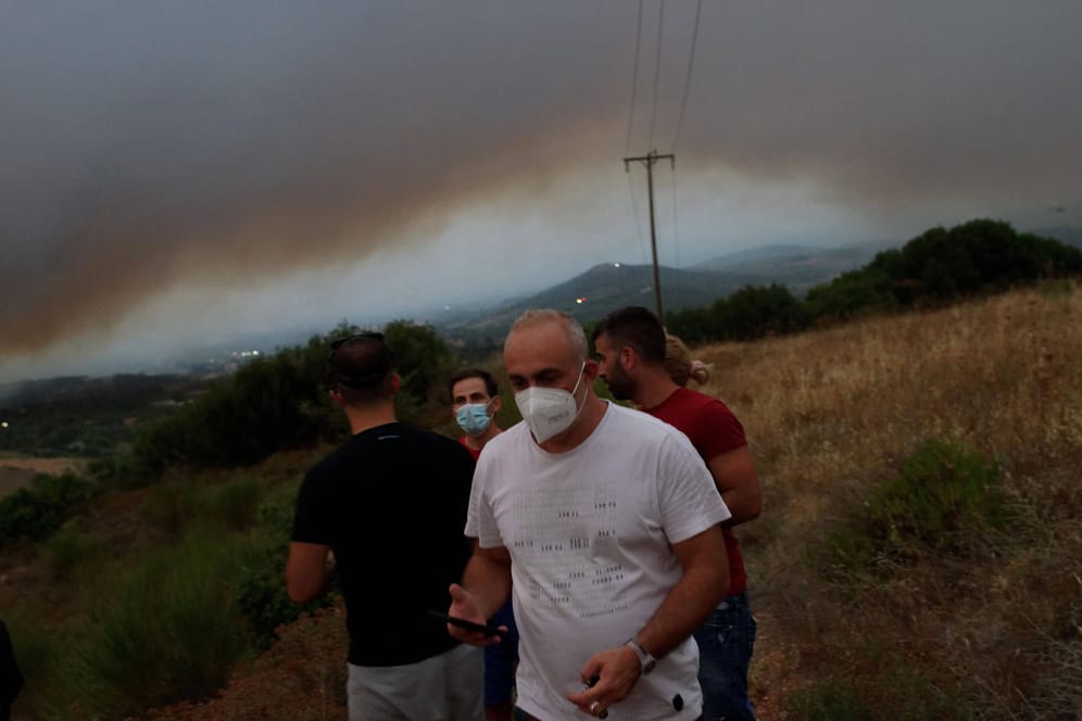 Menschen mit FFP2-Masken im Norden von Athen: Die Feuerwehr ruft Bewohner dazu auf, die Häuser nicht zu verlassen.