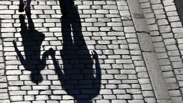 Die Schatten einer erwachsenen Person und eines Kindes