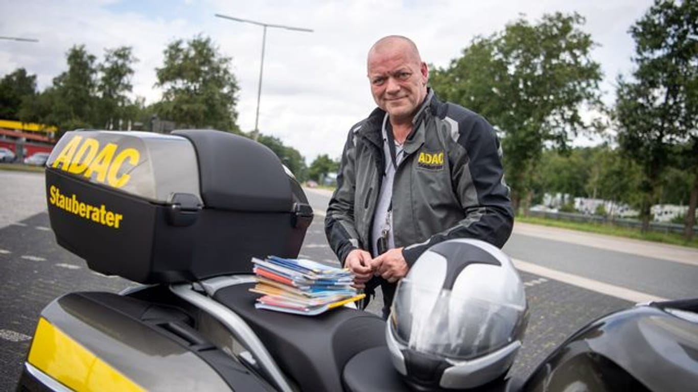 Roger Jahn steht auf einer Raststätte neben seinem Motorrad