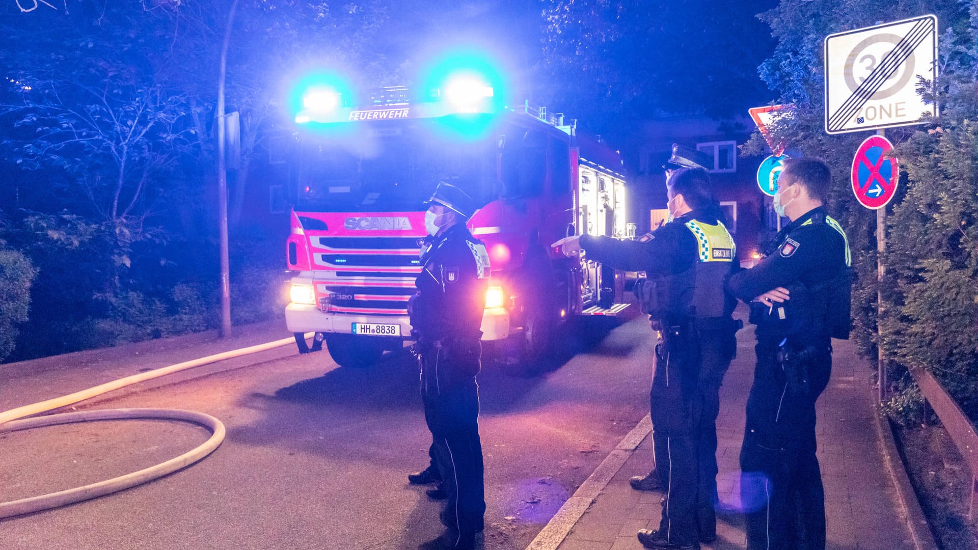 Polizeibeamte stehen vor einem Fahrzeug der Hamburger Feuerwehr: Die gesamte zweite Etage stand in Flammen. Polizeibeamte stehen vor einem Fahrzeug der Hamburger Feuerwehr: Die gesamte zweite Etage stand in Flammen.