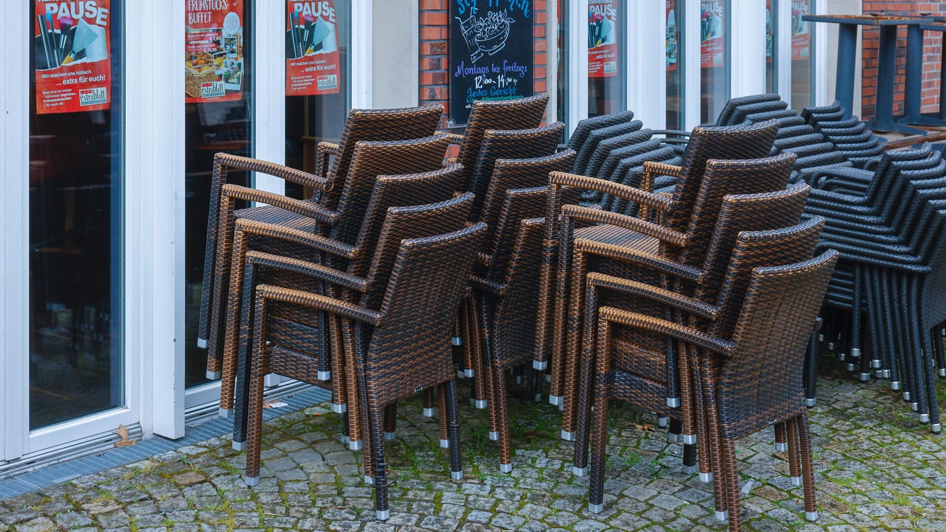 Stühle stehen vor einem geschlossenen Restaurant in Coesfeld (Archivbild). Wirtschaftsverbände warnen vor einem neuen Lockdown.