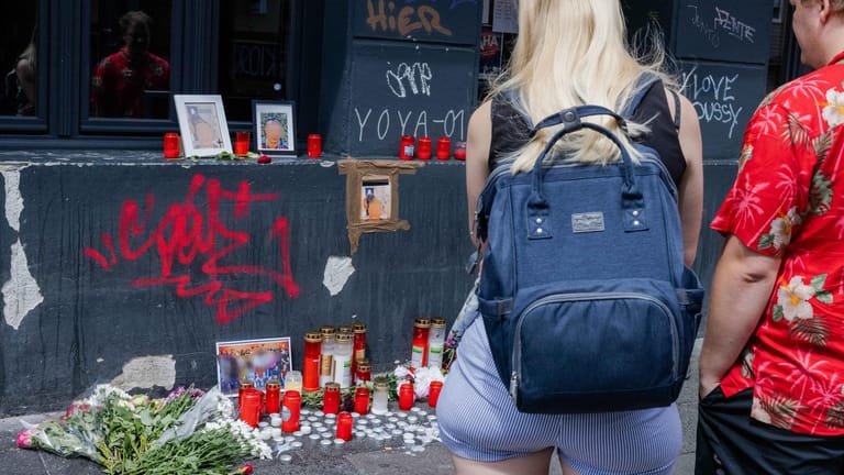 Menschen stehen am Tatort des getöteten 18-Jährigen auf der Zülpicher Straße: Nach der Tat waren hier Kerzen, Fotos und Blumen niedergelegt worden.