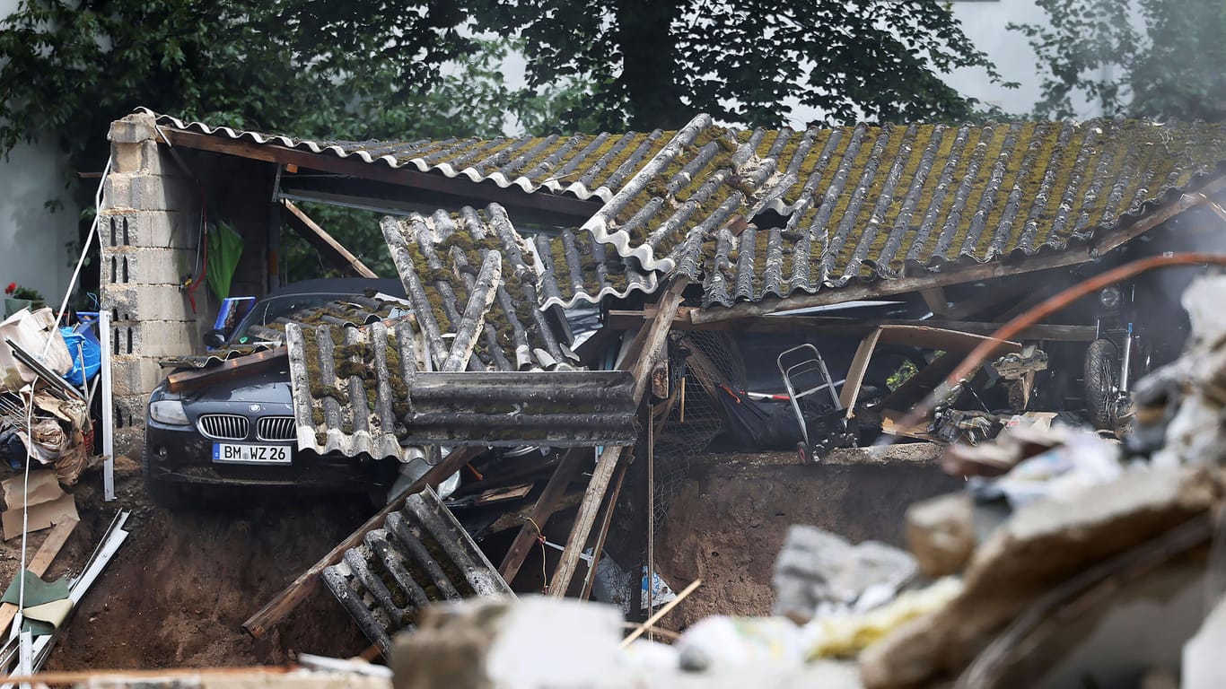 Trümmer bedecken ein Auto am Rande der Kiesgrube: Mehrere Häuser gingen bei einem Erdrutsch verloren, andere waren so stark beschädigt, dass sei abgerissen werden mussten.