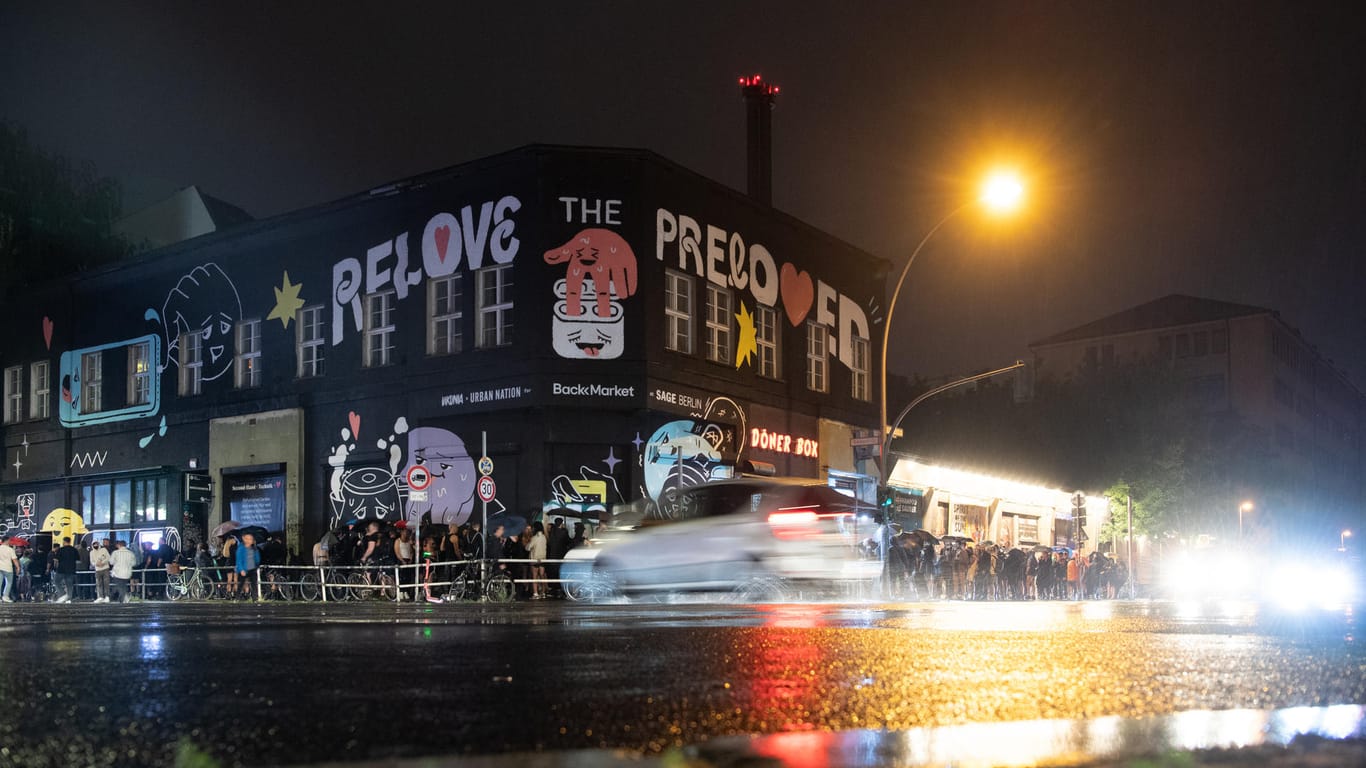 Menschen stehen im strömenden Regen dicht an dicht am Eingang zum KitKat-Club: Im Rahmen eines Pilotprojektes durften Partygänger in sechs Clubs ohne Maske und Abstand tanzen.