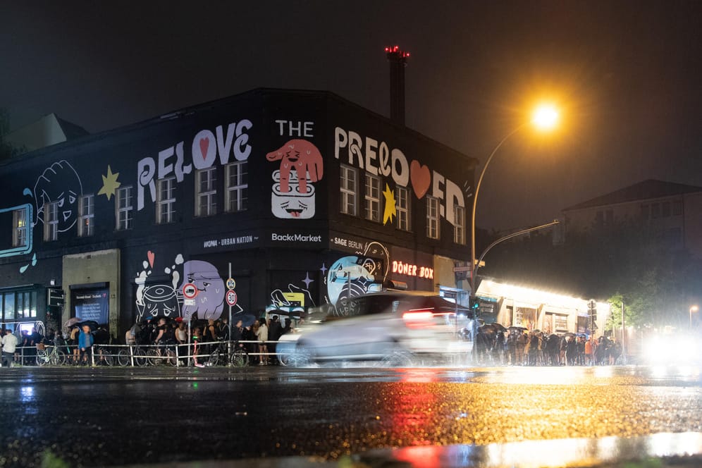 Menschen stehen im strömenden Regen dicht an dicht am Eingang zum KitKat-Club: Im Rahmen eines Pilotprojektes durften Partygänger in sechs Clubs ohne Maske und Abstand tanzen.