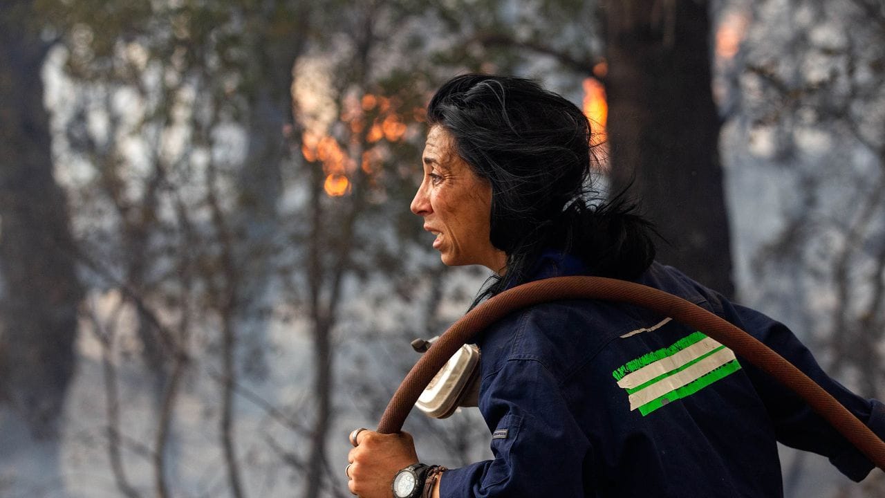 Eine Feuerwehrfrau versucht ein Feuer etwa 30 Kilometer von der griechischen Hauptstadt Athen zu löschen. Eine Feuerwehrfrau versucht ein Feuer etwa 30 Kilometer von der griechischen Hauptstadt Athen zu löschen.
