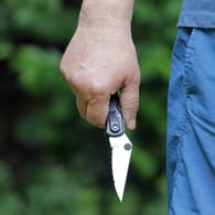 Ein Mann hält ein Messer in der Hand (Symbolbild): In Berlin ist ein 27-Jähriger attackiert worden.