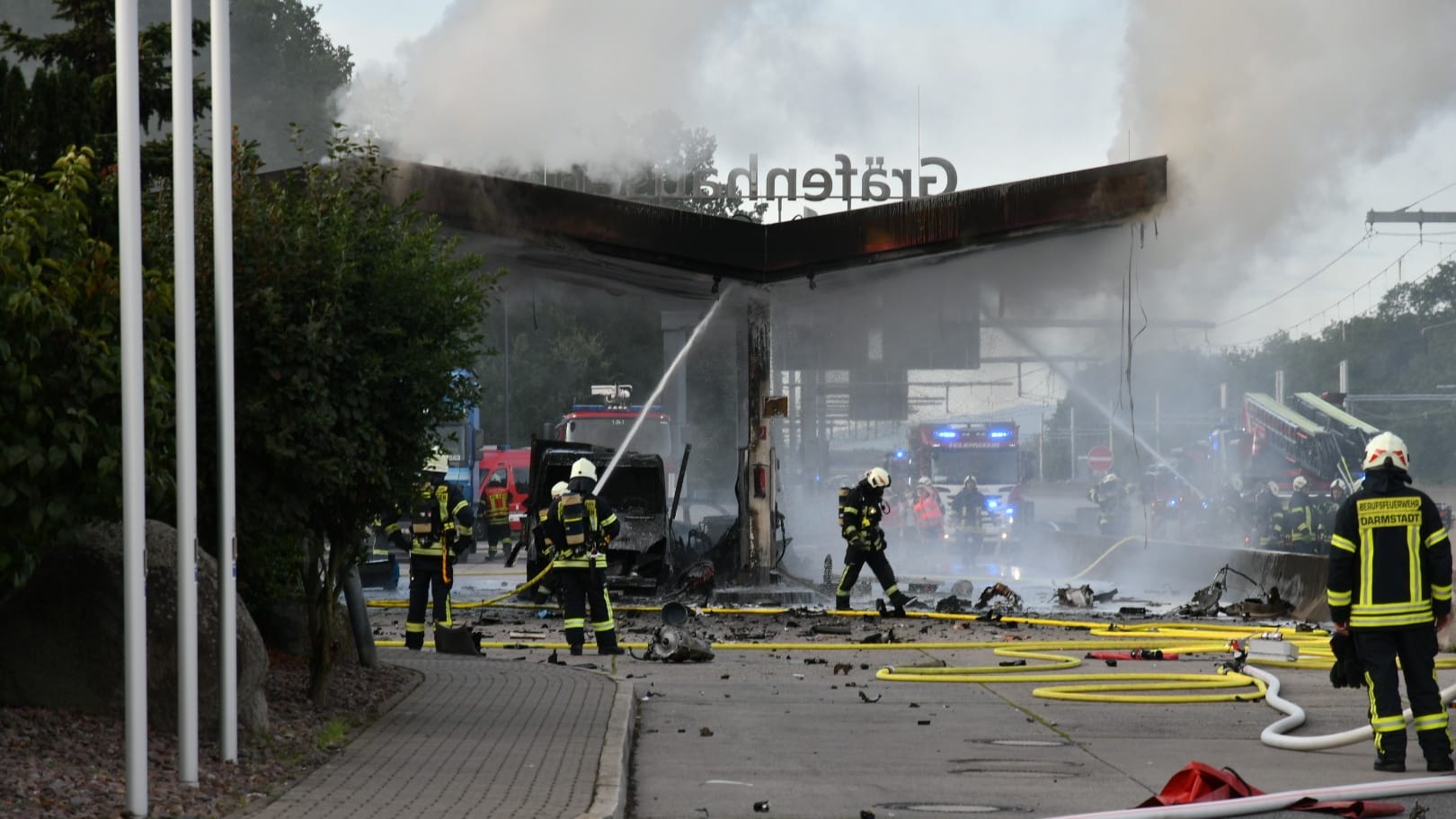 Feuerwehrleute löschen den Brand an der Tankstelle: Am Morgen ist ein Auto in eine der Zapfsäulen gekracht. Feuerwehrleute löschen den Brand an der Tankstelle: Am Morgen ist ein Auto in eine der Zapfsäulen gekracht.