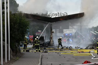 Feuerwehrleute löschen den Brand an der Tankstelle: Am Morgen ist ein Auto in eine der Zapfsäulen gekracht.