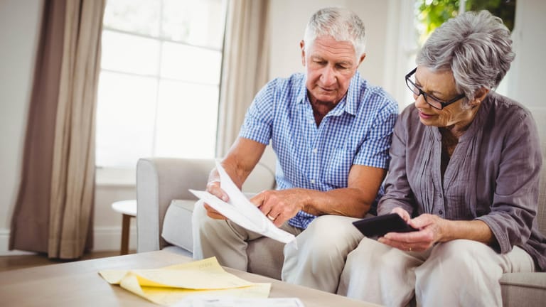 Älteres Paar sichtet Dokumente (Symbolbild): Wer eine Lebensversicherung kündigt, erhält den sogenannten Rückkaufswert.