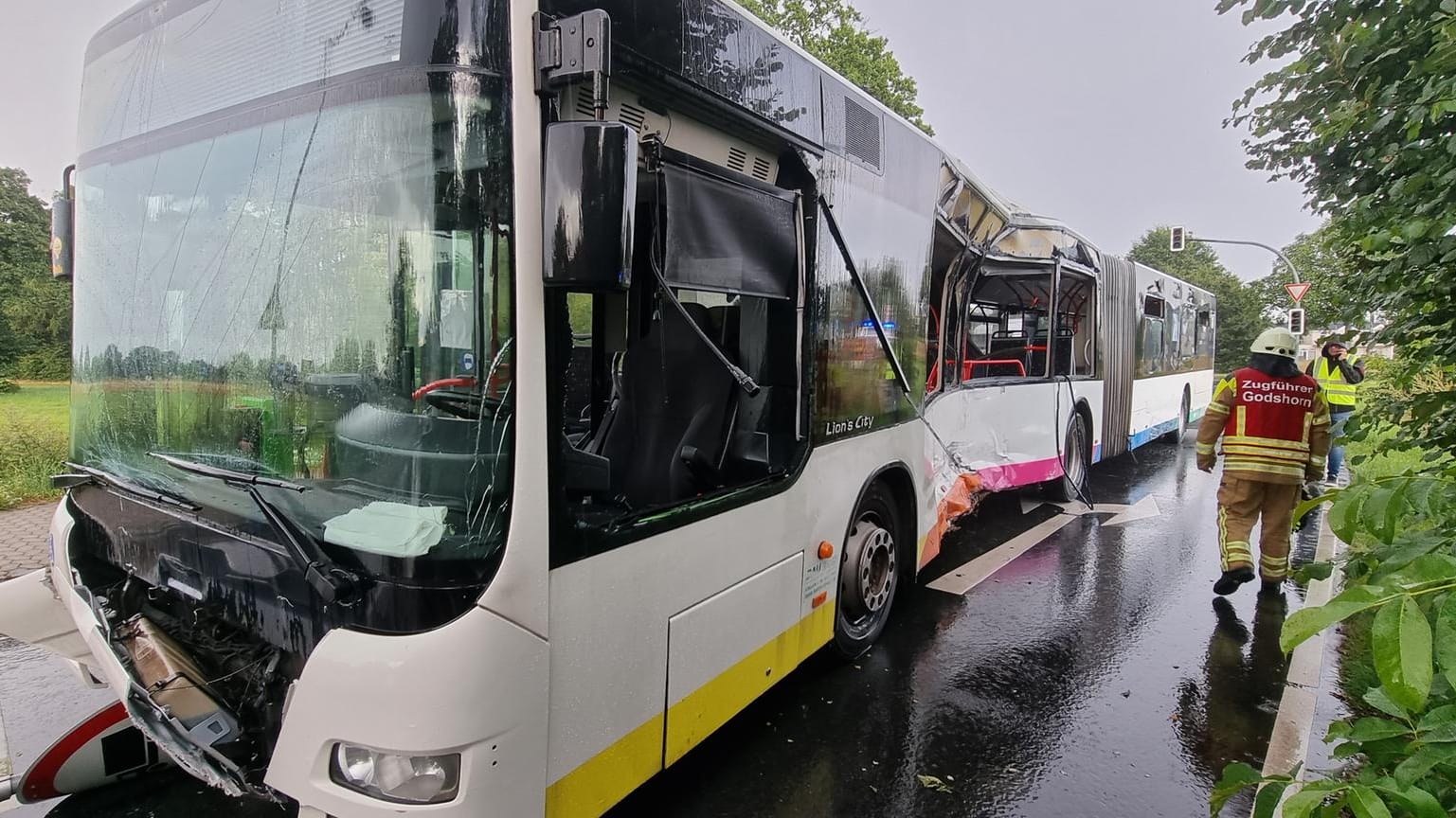 Ein Feuerwehrmann steht bei einem beschädigten Linienbus: Bei einem Zusammenstoß zwischen einem Linienbus und einem Lkw ist ein Mensch tödlich verletzt worden.